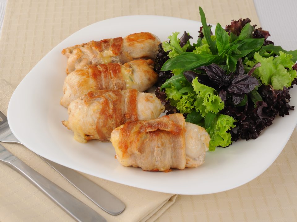 involtini di pollo e prosciutto su piatto con insalata